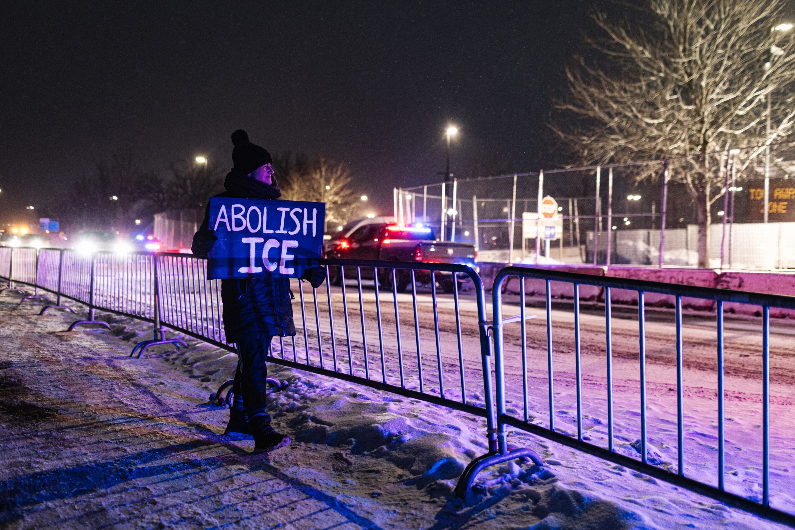 A protester with an anti-ICE sign, stands outside of the Henry Bishop Whipple Federal building on Jan. 18 in Minneapolis, Minn.
